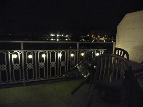 a balcony with two chairs and a railing at night at appartement au calme face au lac in Marciac