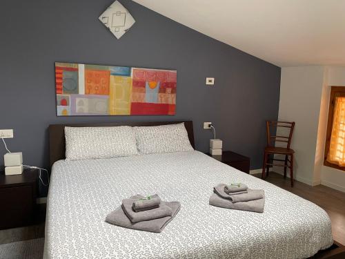 een slaapkamer met een bed met twee handdoeken erop bij Relax Suite Holiday Apartment in Riva del Garda
