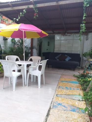 a patio with a table and chairs and an umbrella at Villa mar in Puerto Colombia