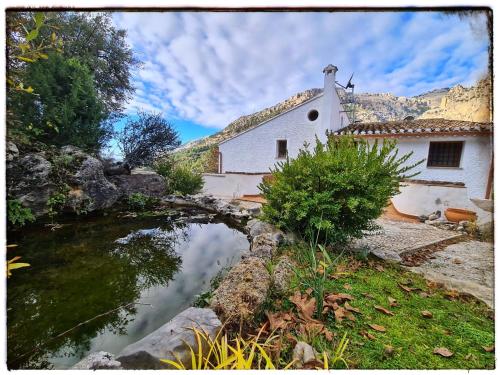 una casa blanca con un puente sobre un río en Saluda Alta en Castril