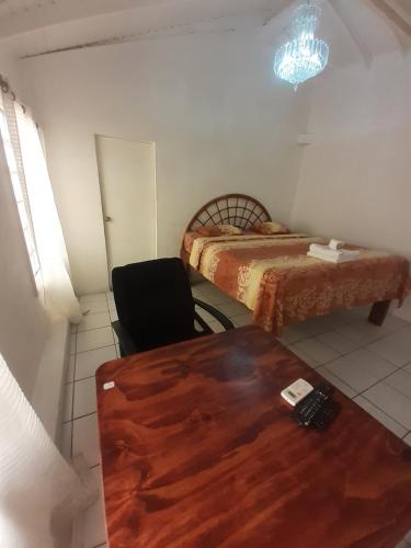 a room with two beds and a table and a chair at Calinago Friendly Family Sxm in Philipsburg
