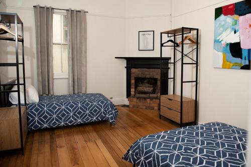 ein Schlafzimmer mit zwei Betten und einem Kamin in der Unterkunft The Met Hotel in Toowoomba