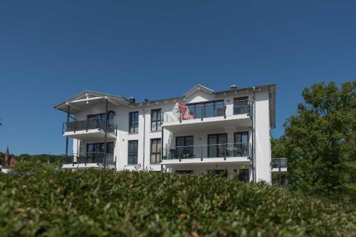 a white building with an american flag in front of it at Bel Etage in der Villa Amelie am M in Sassnitz