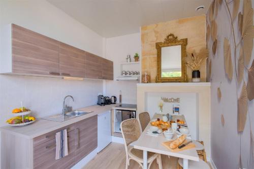 eine Küche mit einem Tisch und einer Obstschale darauf in der Unterkunft Les Suites d'Aliénor-Suite Acanthe in Pessac
