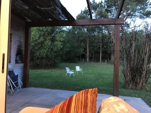 a screened in porch with two chairs in the yard at Casa Marieta Ocean Park in Sauce de Portezuelo