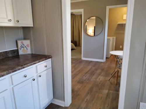a kitchen with white cabinets and a table and a mirror at Comfort in Columbus in Columbus