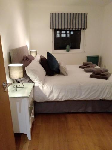 a bedroom with two beds with pillows and a window at Fistral beach apartment in Newquay