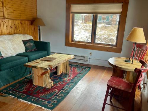 a living room with a green couch and a table at Beyul Retreat in Meredith