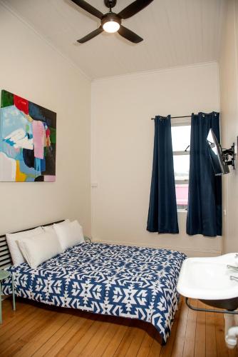 a bedroom with a bed and a ceiling fan at The Met Hotel in Toowoomba