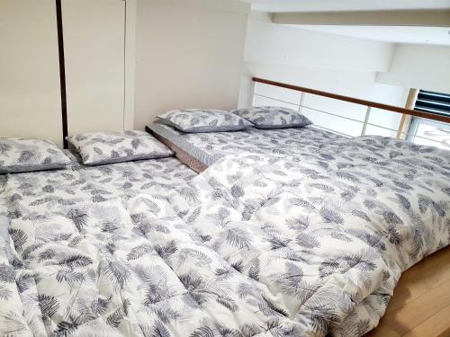 a bedroom with two beds with a white comforter at Y stay in Daegu