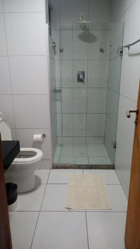 a bathroom with a glass shower and a toilet at Apartamento flat - Iloa Residence 1 in Barra de São Miguel