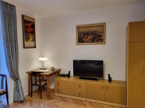 華沙的住宿－W Kolorze Mięty，客厅配有木柜上的平面电视