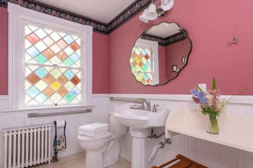 a bathroom with a toilet, sink, and mirror at Sinclair Inn Bed & Breakfast in Jericho