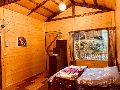 a bedroom with a bed in a wooden cabin at Golden Leather Carving Studio in Leye