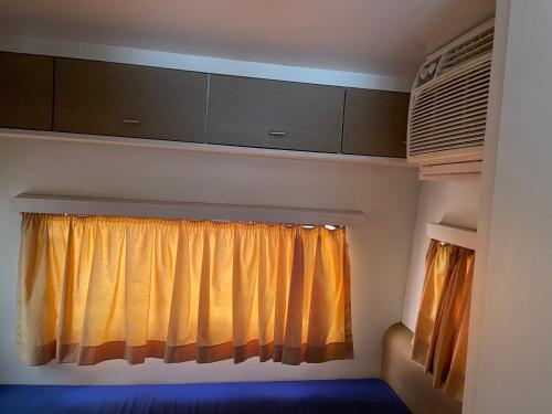 ein Fenster in einem Zimmer mit einem Vorhang in der Unterkunft Trailer, Esporte e Amigos in Atibaia