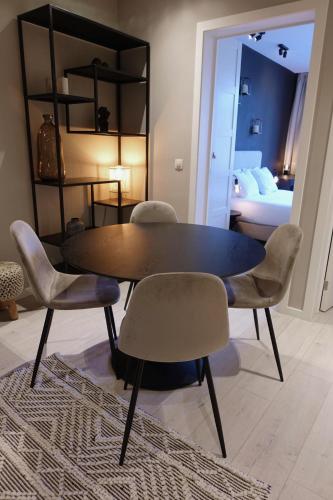 a table and chairs in a room with a bedroom at 3 Room Luxury Design Apartment with Airconditioning, Close to Gent St-Pieters Station in Ghent