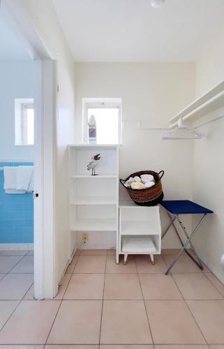 a bathroom with a shelf and a basket on a tiled floor at Tropic Isle Hotel & Apartment in Hollywood