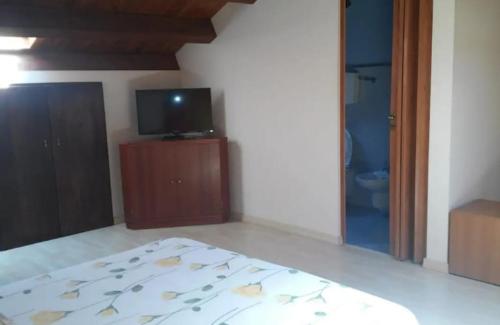 1 dormitorio con 1 cama y TV y 1 habitación en Casa indipendente a pochi passi dal mare, en Bova Marina