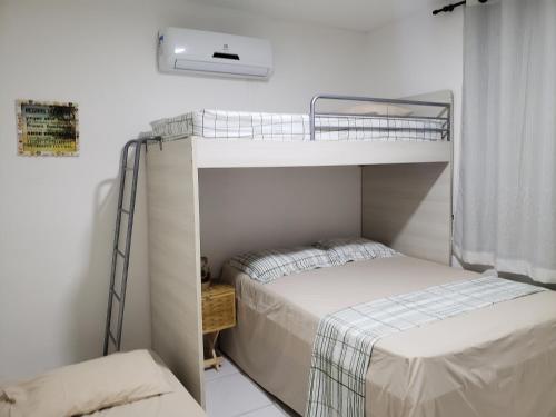 a bedroom with two bunk beds and a window at Chaleville Coqueiro 1001 in Luis Correia