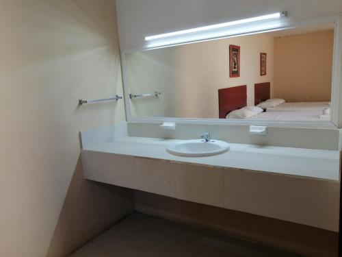 a bathroom with a sink and a large mirror at Hotel Bugambilia Campeche in Campeche