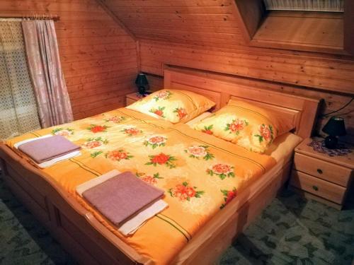 een bed in een houten kamer met handdoeken erop bij Gästehaus Deisl in Mariapfarr