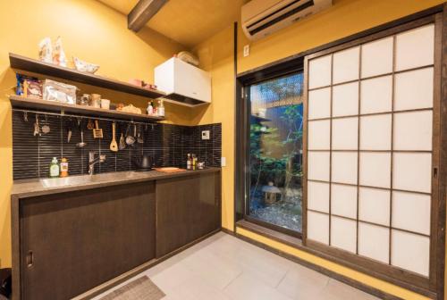 a kitchen with a counter and a large window at Hotel Zipangu Tameikecho in Kyoto