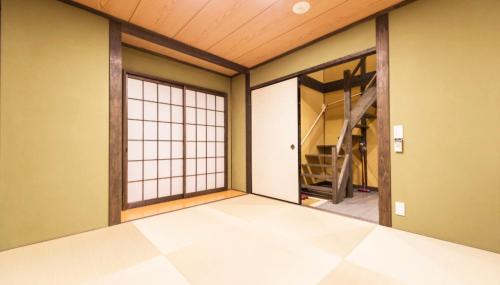 an empty room with a large window and a staircase at Hotel Zipangu Tameikecho in Kyoto