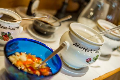 un tavolo con due tazze e una ciotola di cibo di Hotel Kompatscherhof a Luson