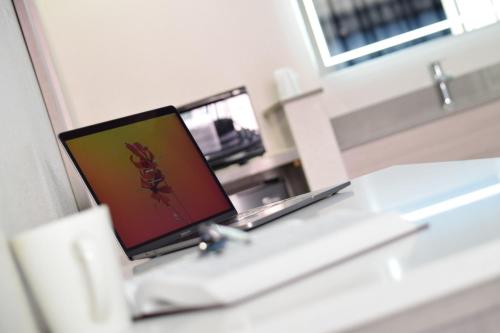 a laptop computer sitting on top of a desk at Mojave Inn in Victorville