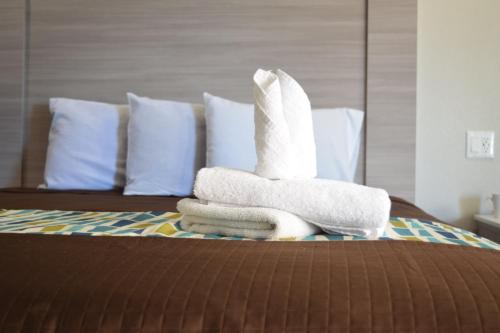 a pile of towels sitting on top of a bed at Mojave Inn in Victorville