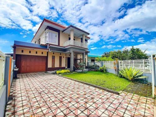 a large house with a white fence and a driveway at REESTY VILLA KOLAM RENANG VIEW GUNUNG dekat ALUN2 in Batu