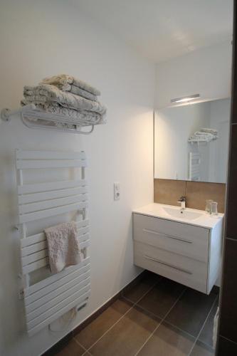 une salle de bain avec un lavabo et un miroir dans l'établissement La Balade des Marais, à Saint-Molf
