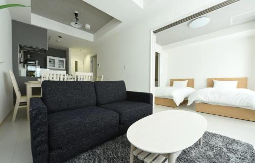 ein Wohnzimmer mit einem Sofa, einem Bett und einem Tisch in der Unterkunft Hills Garden Hondori / Vacation STAY 7586 in Sapporo