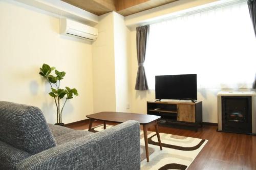 a living room with a couch and a tv at Hills Garden Hondori / Vacation STAY 7576 in Sapporo
