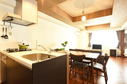 a kitchen with a sink and a table with chairs at Hills Garden Hondori / Vacation STAY 7576 in Sapporo
