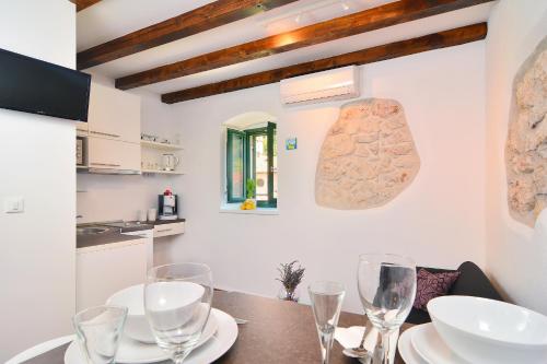 uma sala de jantar com uma mesa com copos de vinho em Apartments and Rooms Kampanel em Hvar
