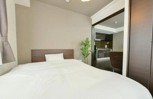 a bedroom with a large white bed with a mirror at Suncourt Minami 6jo Nibankan / Vacation STAY 7447 in Sapporo