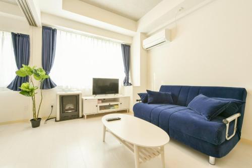 a living room with a blue couch and a table at Hills Garden Hondori - Vacation STAY 8406 in Sapporo