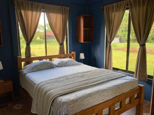 a bedroom with a bed with blue walls and windows at Casitas Joys & Leo - Rana in Santa Rita