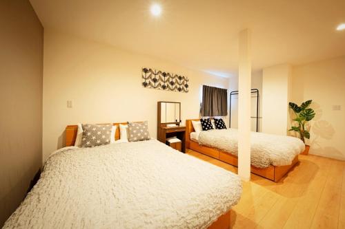 a bedroom with two beds and a mirror at Sapporo - Apartment - Vacation STAY 7939 in Sapporo