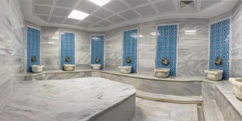 a white bathroom with four toilets and blue windows at ES TERMAL OTEL&SPA in Derekoy