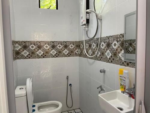 a bathroom with a shower and a toilet and a sink at Laura Guest House Langkawi in Pantai Cenang