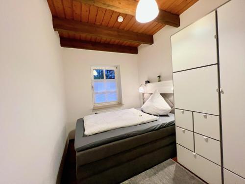 um pequeno quarto com uma cama e uma janela em 2 Zimmer Business Wohnung mit Terrasse em Ahrensburg