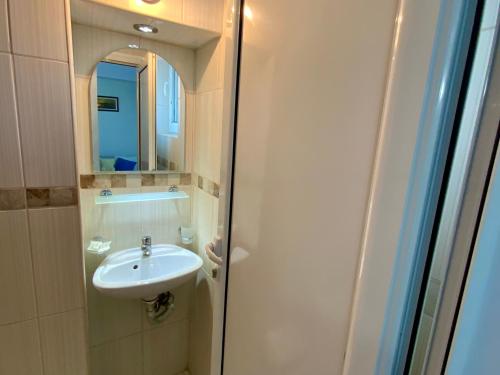ein Bad mit einem Waschbecken und einem Spiegel in der Unterkunft Guest House Briz in Nessebar