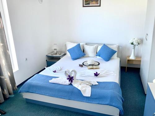 a bedroom with a bed with blue and white furniture at Guest House Briz in Nesebar