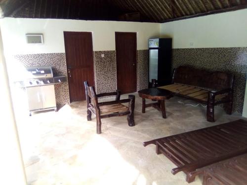 a living room with benches and a table and a stove at Villa LeoMar Diani Beach in Diani Beach