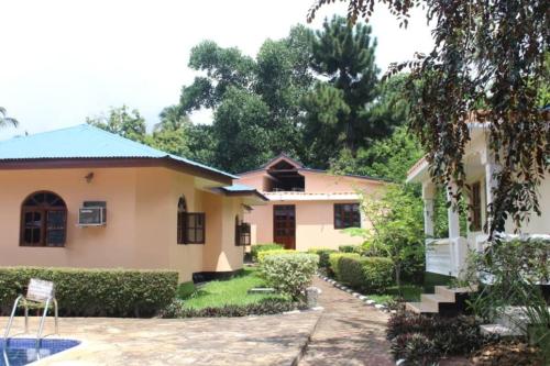 a small yellow house with a garden and trees at Safina Resort in Zanzibar City
