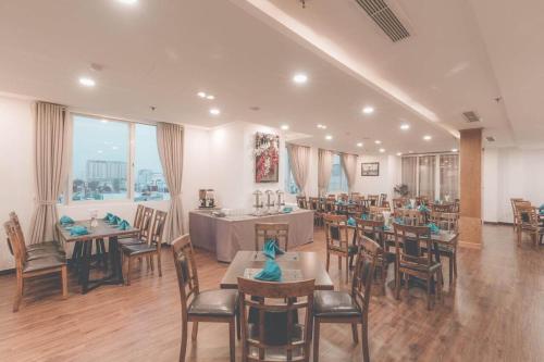 een restaurant met tafels en stoelen in een kamer bij A25 Hotel - Lê Thị Hồng Gấm in Ho Chi Minh-stad