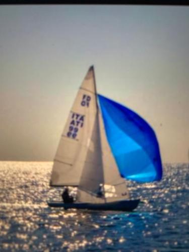 a sailboat with a blue and white sail on the water at LA CONCHIGLIA A MARINA in Marina di Carrara