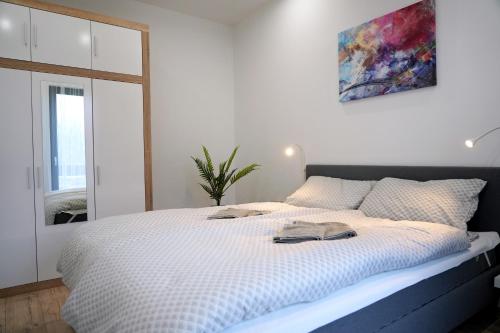Apartmán Zuzana في Nesvady: غرفة نوم مع سرير أبيض كبير مع مرآة